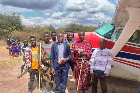 Group gathers in front of plane