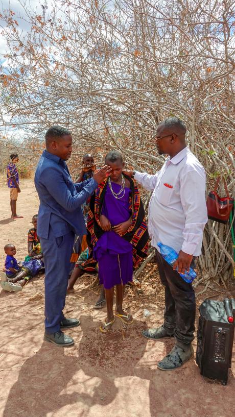 Pastor Emmanuel conducts a baptism during the evangelistic session in Dabia airstrip.