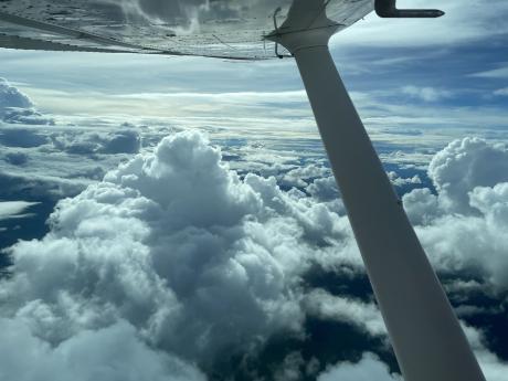 View of aircraft wing and clouds out window