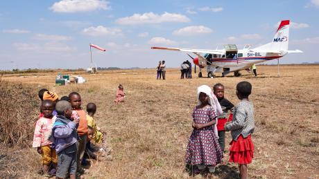 People gather to watch the aircraft after stepping down in Njombe.
